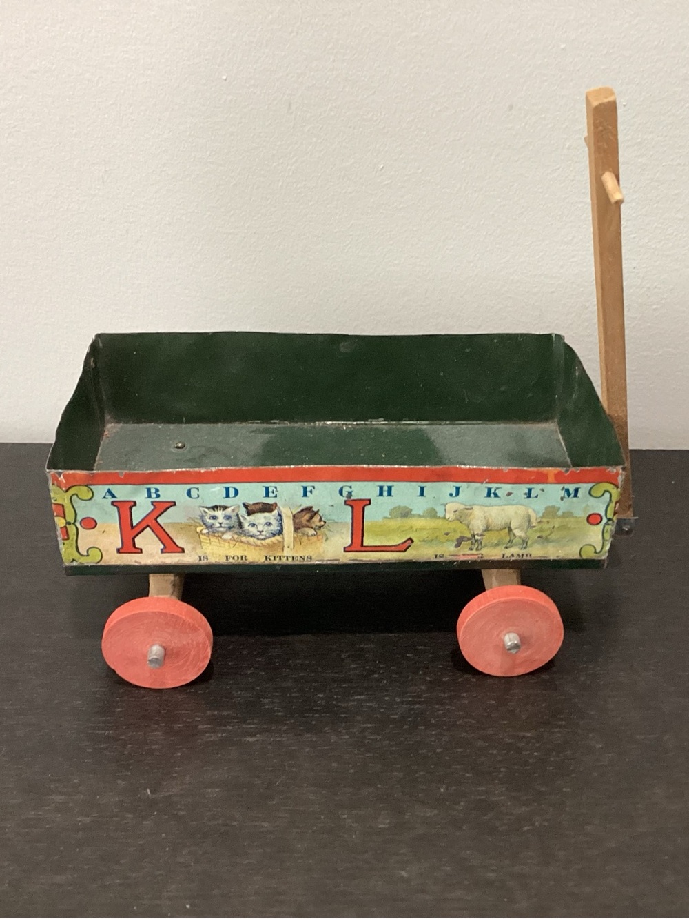 Antique Tin Lithographed illustrations wrapped around the outside of the wagon.